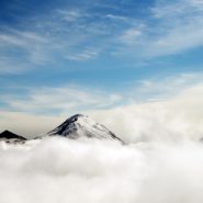 a photo of mountain peaks rising above clouds