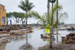 Flooding and cleanup workers at a tropical oceanside city