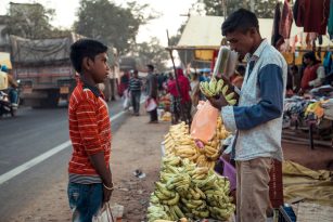 Two children in India talking at a market